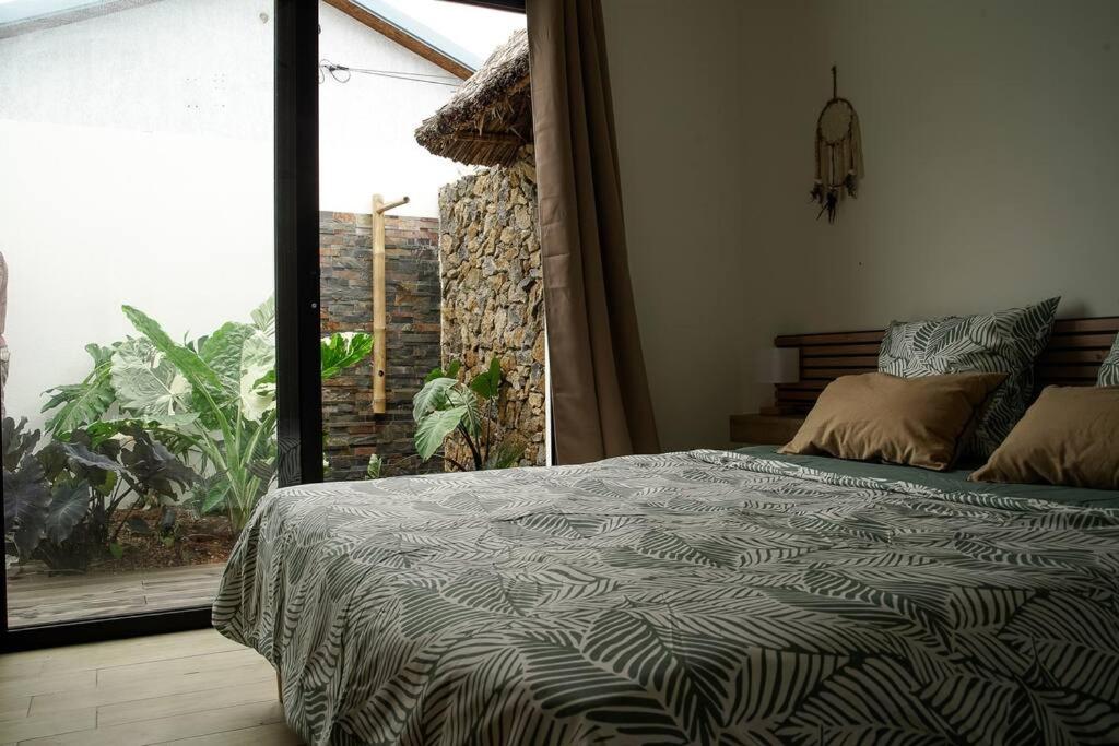 Un dormitorio con una cama y una ventana grande en Villa Savio, en Saint-Pierre