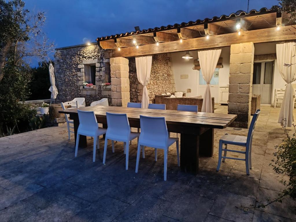 Una mesa y sillas de madera en un patio. en Villa Delfino, en San Foca