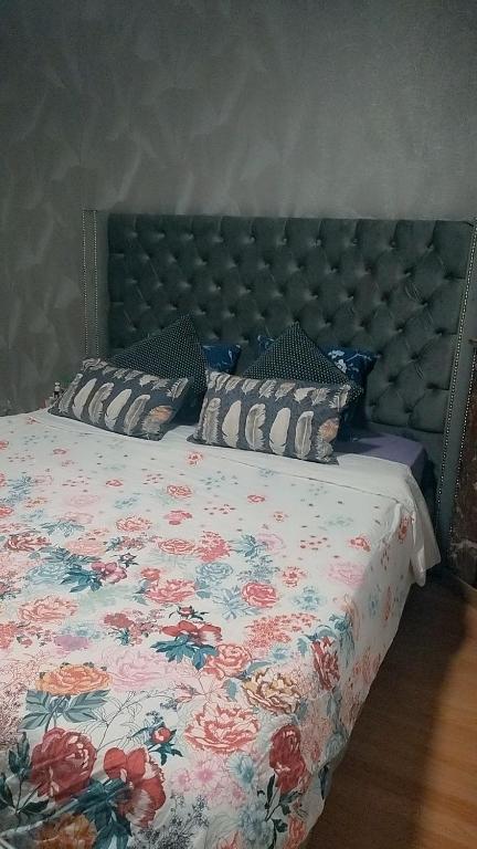- un lit avec un couvre-lit floral et des oreillers dans l'établissement Appartement, à Aubervilliers