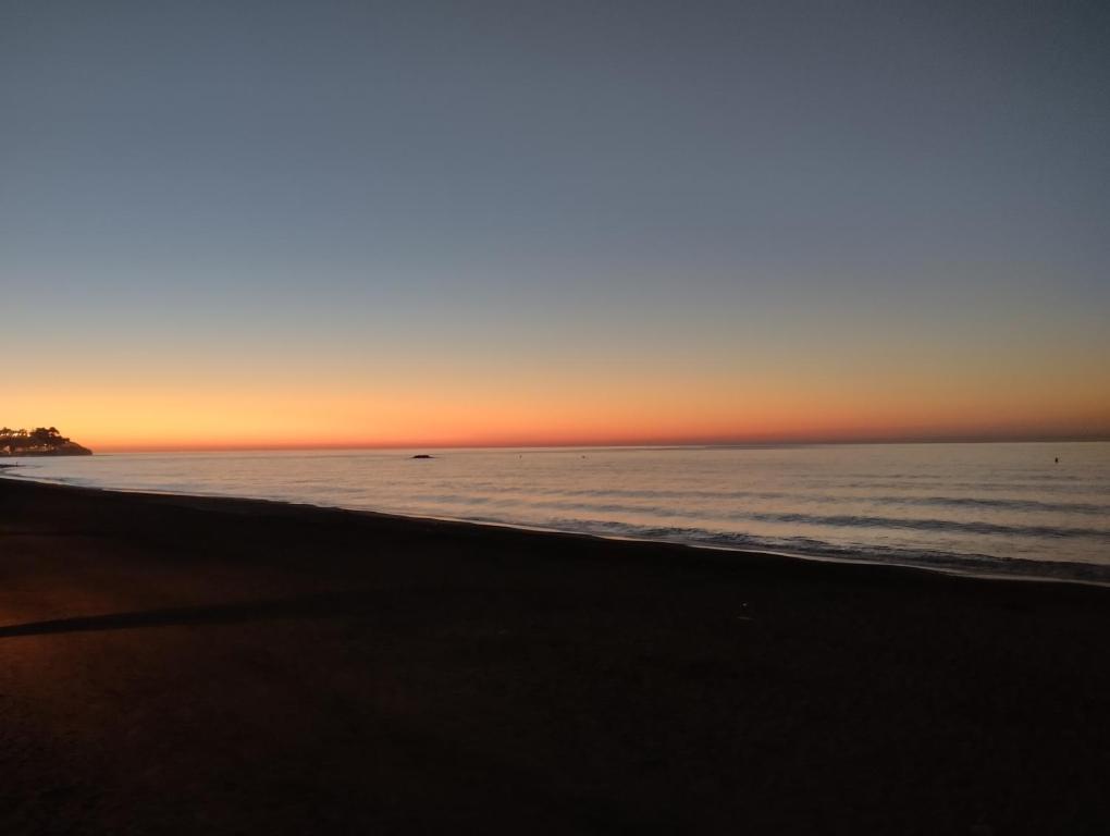 a sunset on a beach with the ocean at Villa Jade Beach in Cala del Moral