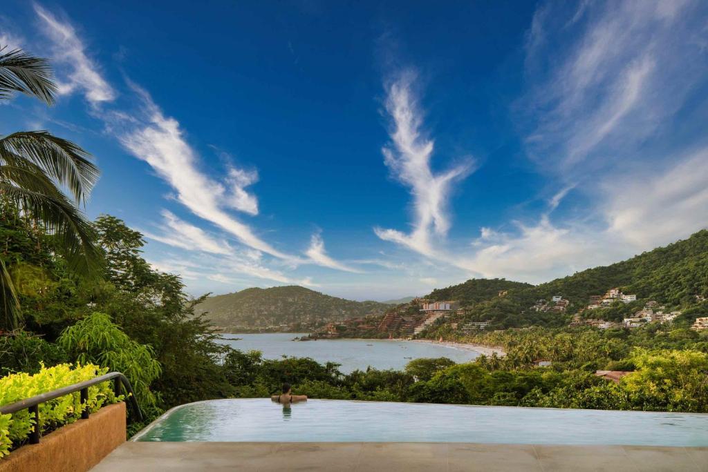 une piscine avec vue sur un plan d'eau dans l'établissement Armadillo Living Villas, à Zihuatanejo