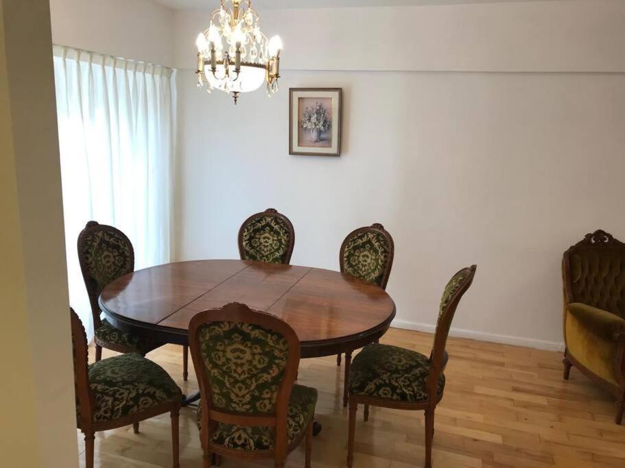a dining room with a wooden table and chairs at Departamento de categoría in Ramos Mejía