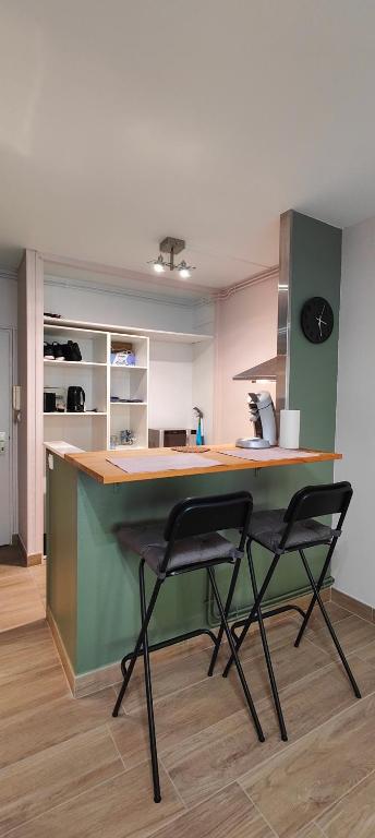 une cuisine avec deux chaises noires au comptoir dans l'établissement Thabor-centre-METRO-commerces, à Rennes