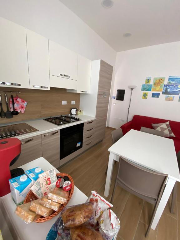 a kitchen with white cabinets and a table with food on it at Little House Galileo in Reggio di Calabria