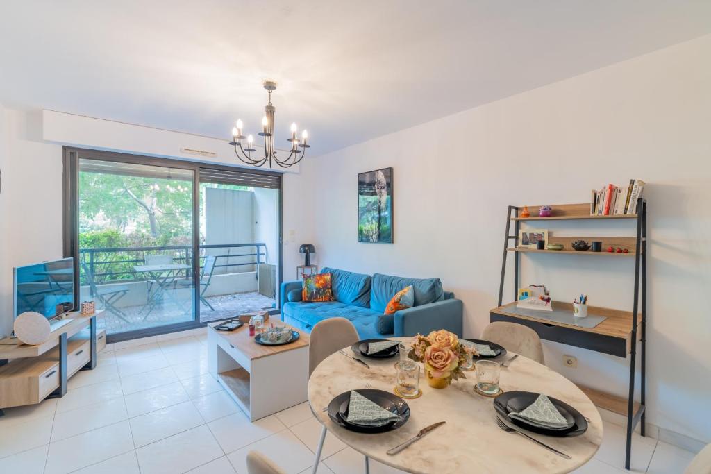 un salon avec une table et un canapé bleu dans l'établissement Le Borely, côté Marina Olympique, à Marseille