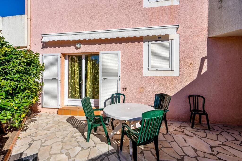 un patio avec une table et des chaises devant un bâtiment dans l'établissement Coquet, terrasse, BBQ, Clim, parking, proche plage, à Sète