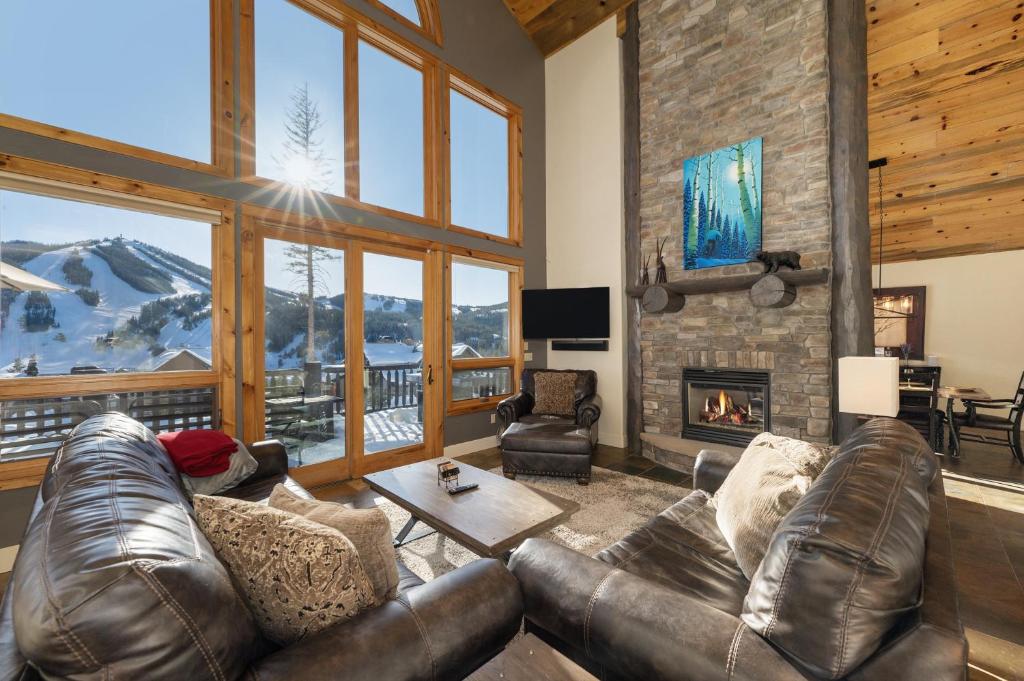 a living room with a leather couch and a fireplace at Dreamcatcher at Lakota home in Winter Park