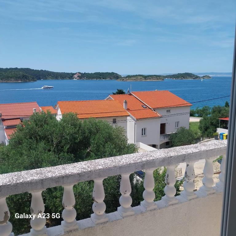 a balcony with a view of the water and buildings at Apartman Tatjana in Rab