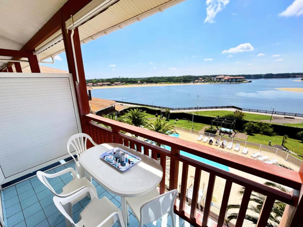 d'un balcon avec une table et des chaises et une vue sur l'eau. dans l'établissement Résidence Le Boucanier - 2 Pièces pour 4 Personnes 004, à Vieux-Boucau-les-Bains