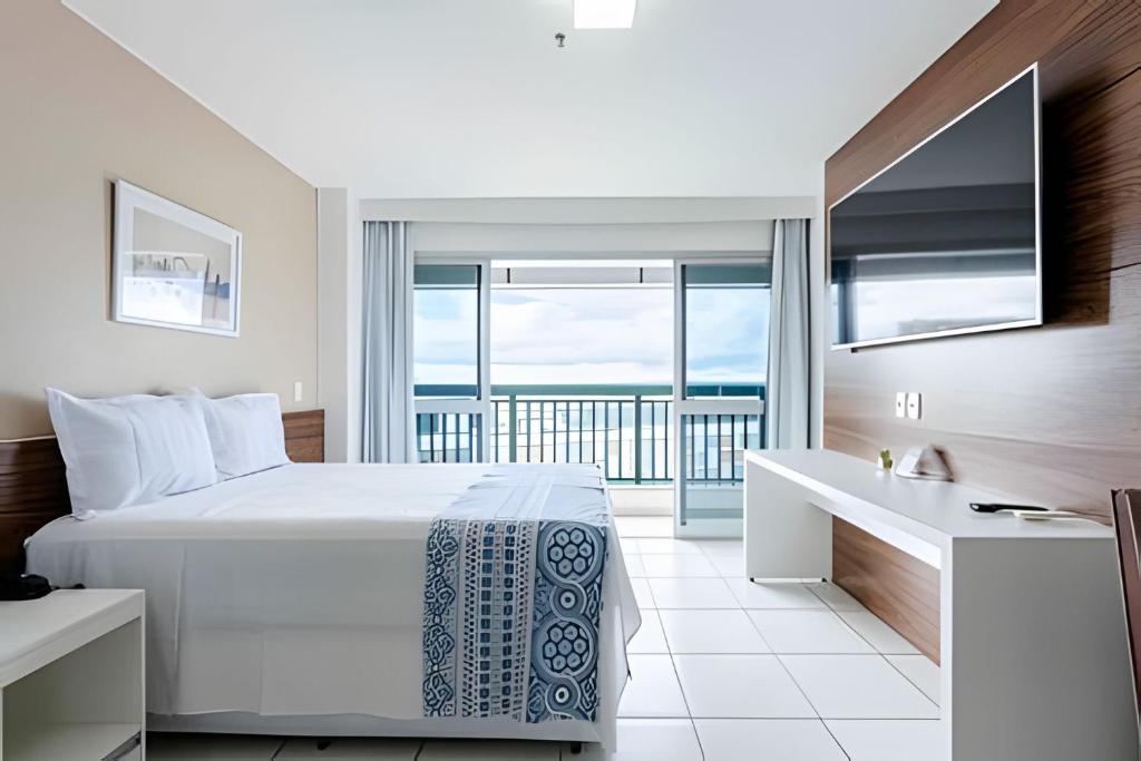 a bedroom with a bed and a desk with a view at Hotel VISION in Brasilia