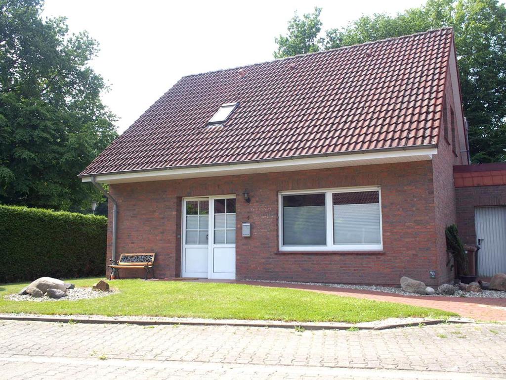 ein kleines Backsteinhaus mit weißer Tür in der Unterkunft Ferienhaus mit Sauna "Waldrausch" - An der Rehwiese 1 RE01 in Sögel