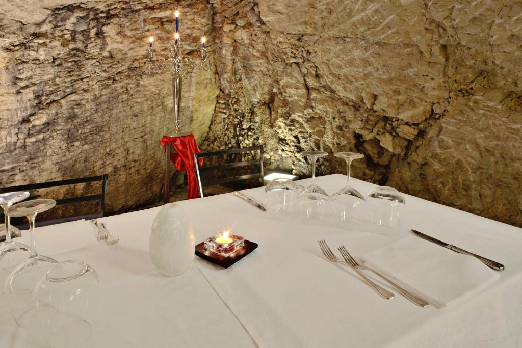 a table with a candle on a table in a cave at Hotel Silvana in San Marino