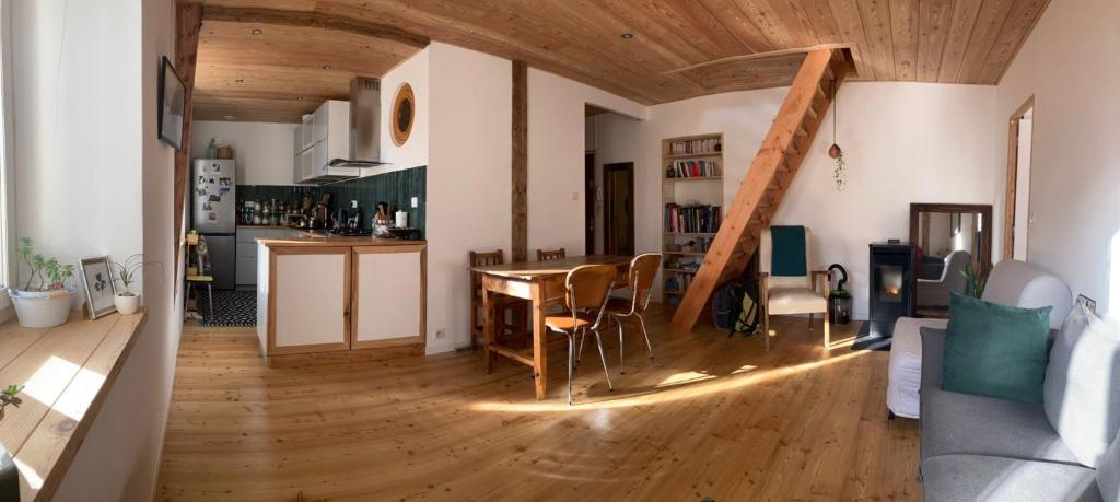 une cuisine et un salon avec une table et des chaises dans l'établissement T3 Briançon avec pan d'escalade, à Briançon