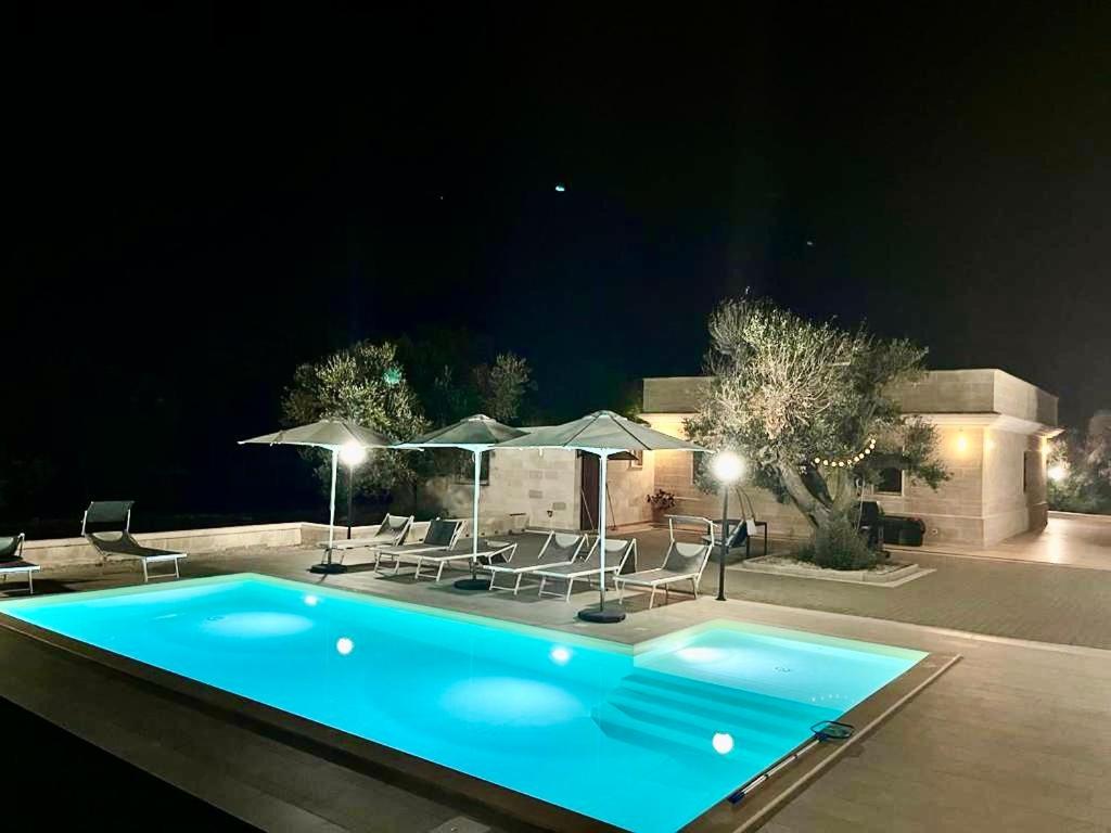 - une piscine avec chaises longues et parasols la nuit dans l'établissement Villa Lara - mit separatem extra Zimmer mit Wc und Dusche, à San Vito dei Normanni