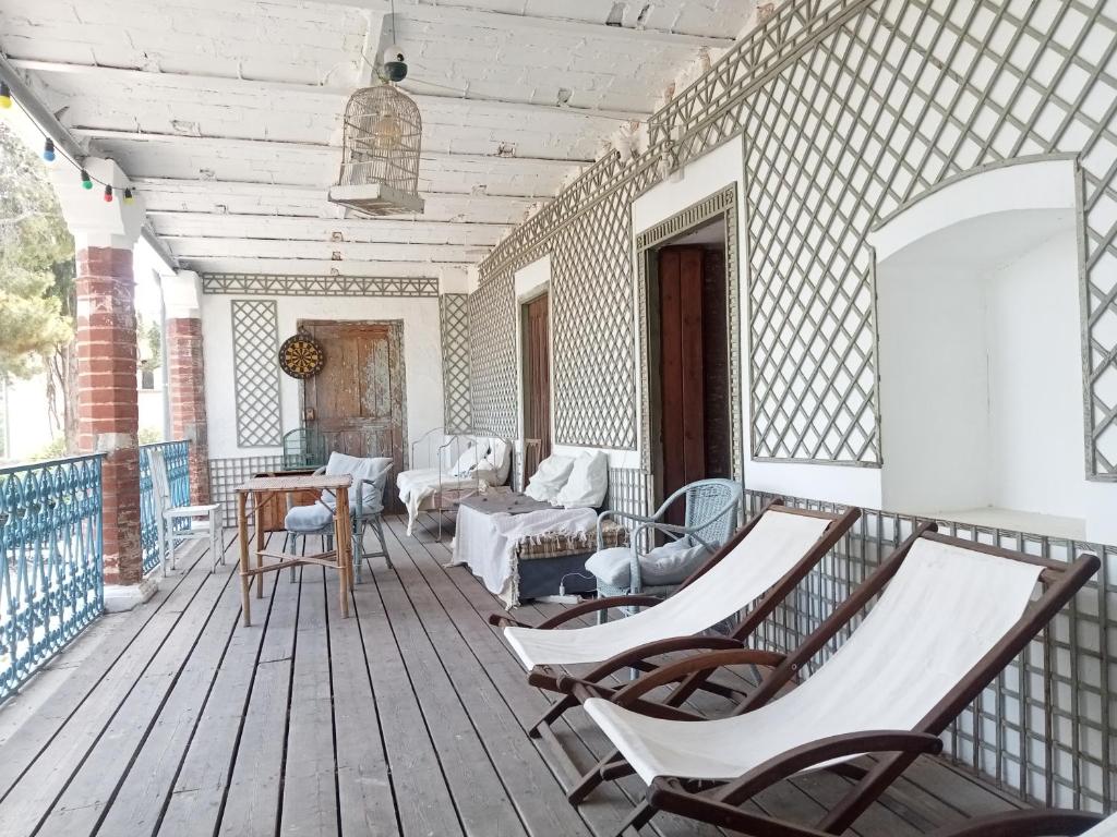 a porch with chairs and a couch on a deck at Le Mas Palegry Chambres d'hôtes Perpignan in Perpignan