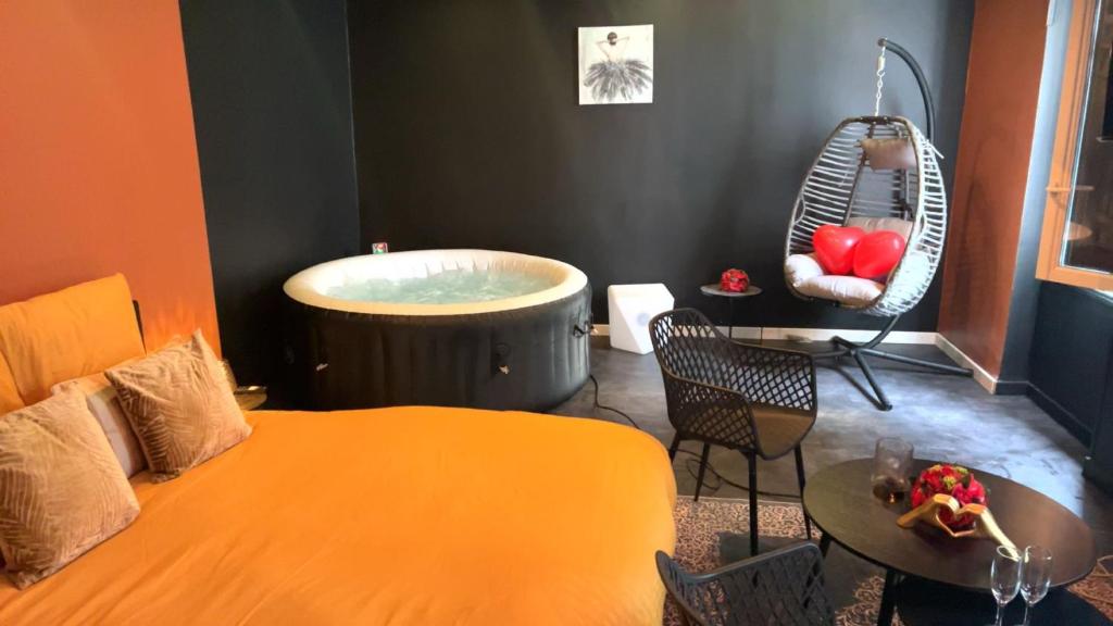 1 dormitorio con bañera, cama y mesa en Love room, en Melun