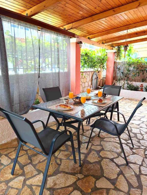 a table and chairs sitting on a patio at Marlene in Karavomylos