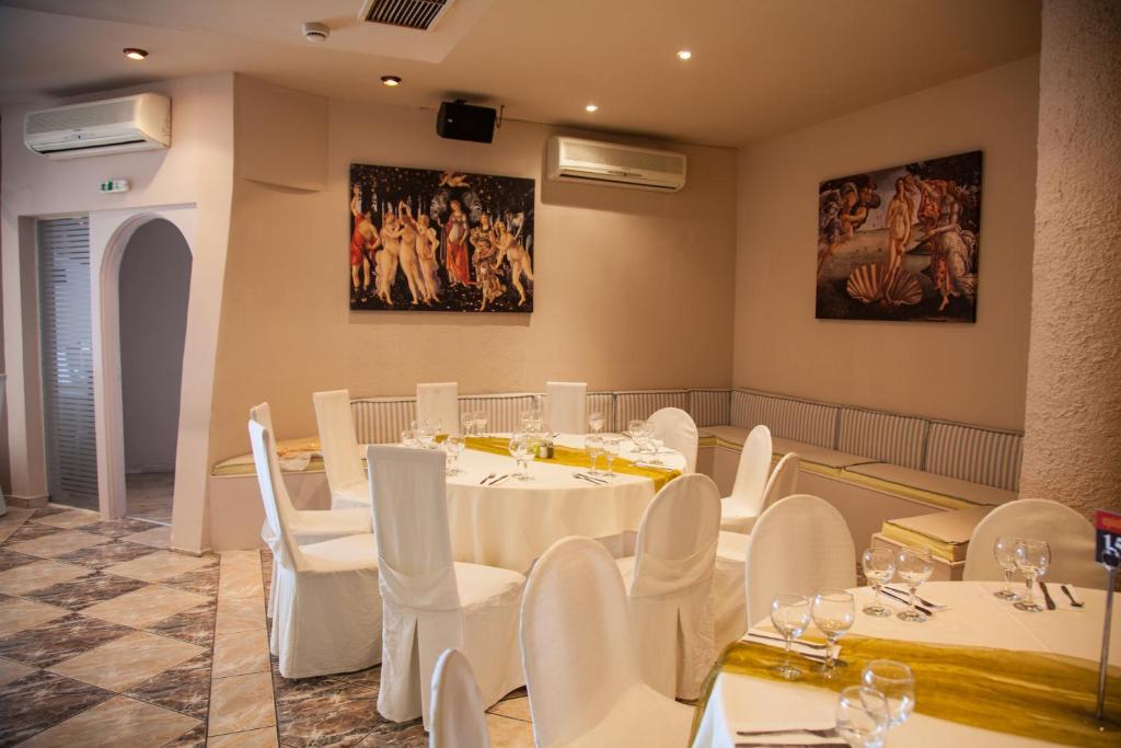 a dining room with white tables and white chairs at Galini Palace in Athens