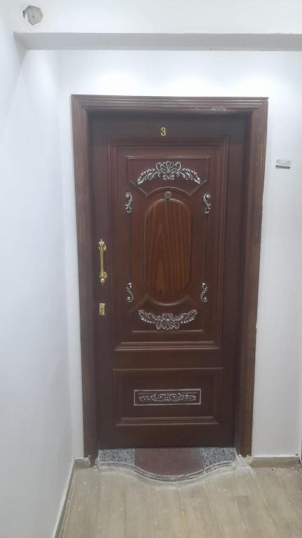 a large wooden door in the corner of a room at استديوهات3 Hs Hotels استديو مخدوم in Cairo
