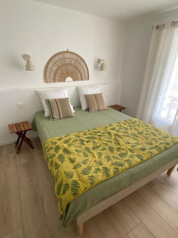 une chambre avec un grand lit avec une couverture jaune dans l'établissement Entre mer et montagne, à Porto-Vecchio