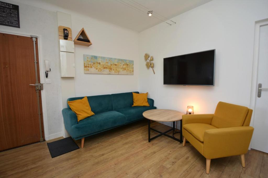 un salon avec un canapé, une table et une télévision dans l'établissement BellaVita - Cosy & Moderne - Proche des remparts - Climatisation, à Avignon