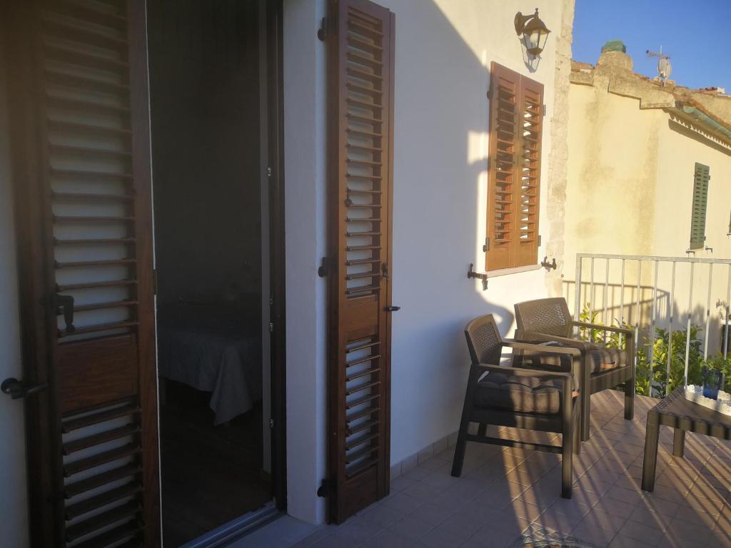 a door to a balcony with a chair and a table at casa del corso 27 in Sirolo