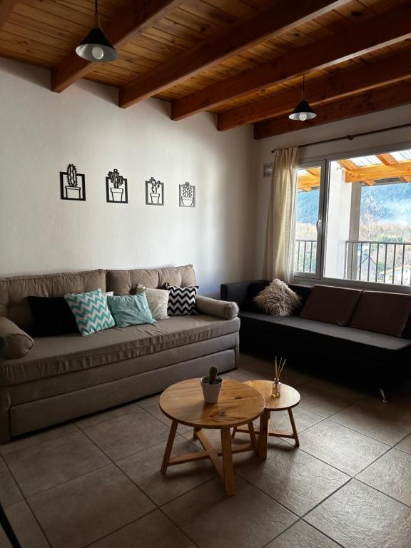 una sala de estar con un sofá y una mesa en Departamento Mallin Azul, en El Bolsón