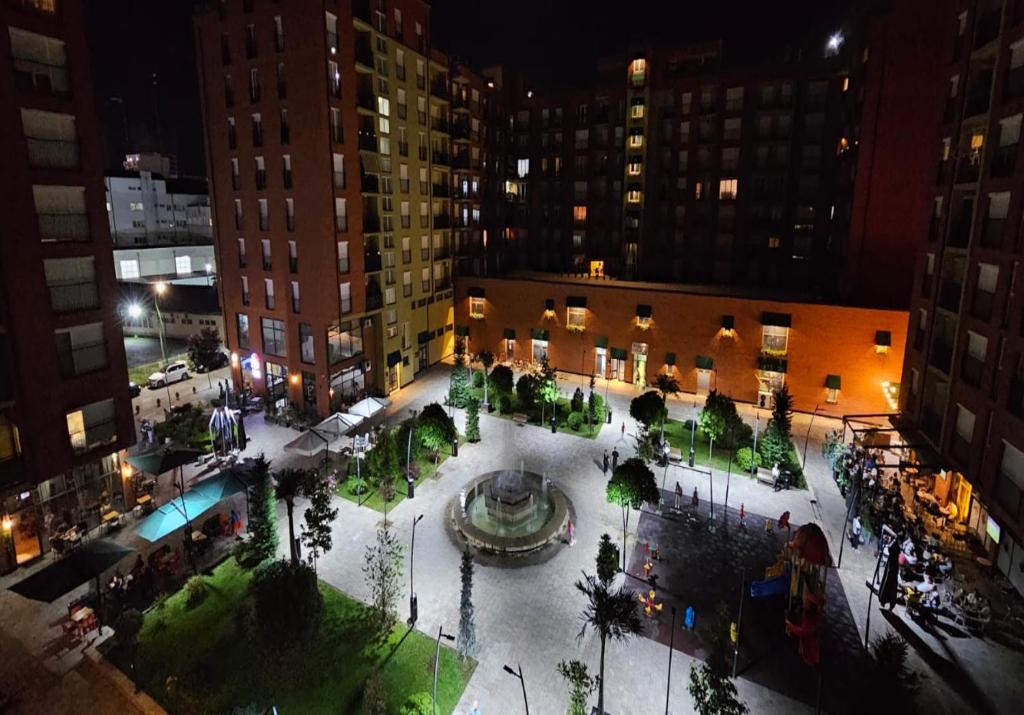 a courtyard with a fountain in a city at night at Superb 1 bedroom in the best zone of the city. in Ferizaj