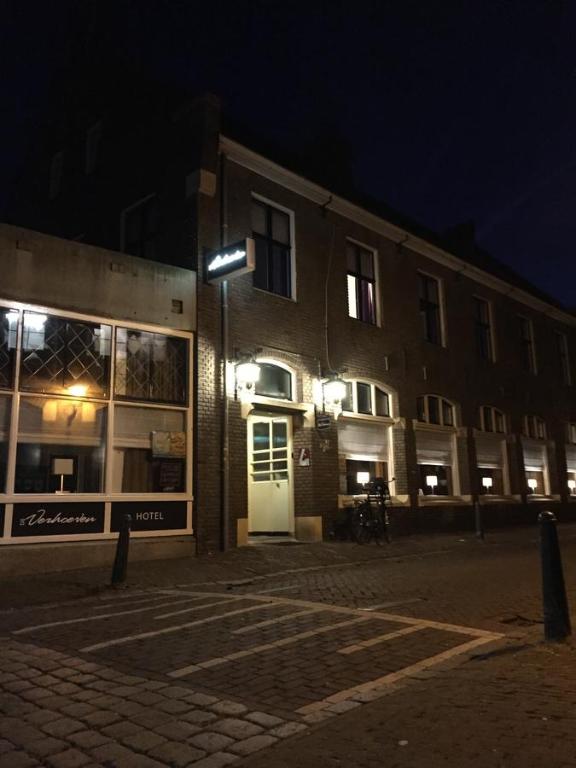 um edifício com uma luz de rua em frente à noite em Hotel Bij Verhoeven em Zevenbergen