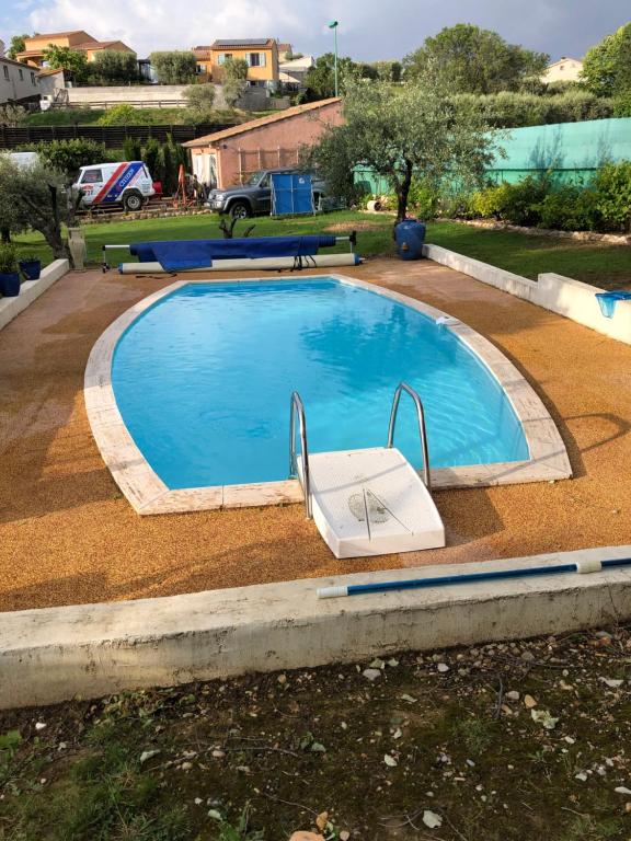 a large swimming pool with a chair in a yard at Chambres d'hôtes Marylou in Valensole