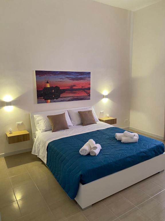 una camera da letto con un letto con due asciugamani sopra di LaPignaapartments a Marsala