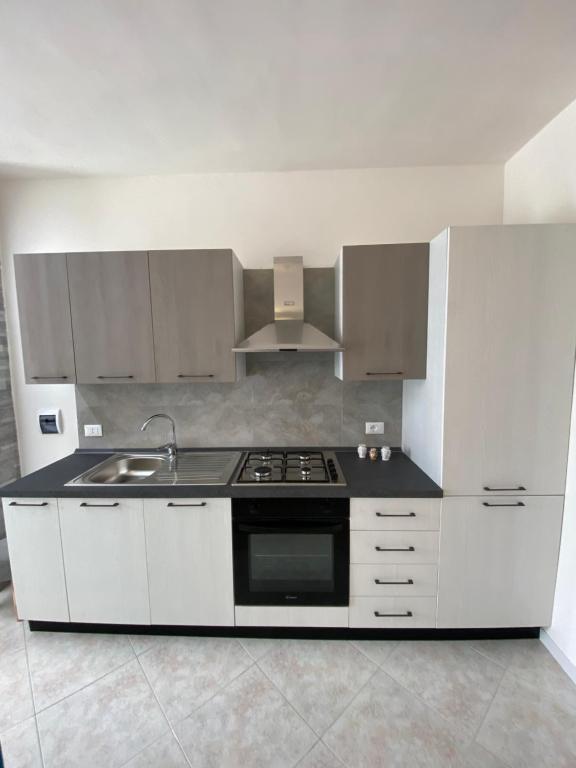 una cucina bianca con fornelli e lavello di LaPignaapartments a Marsala