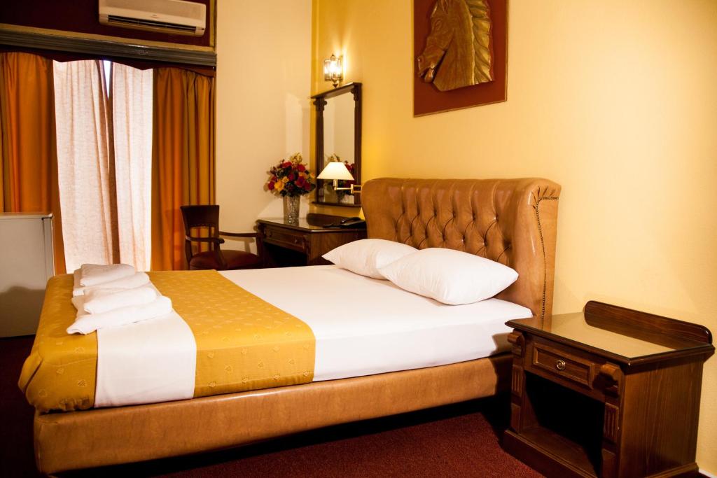 a hotel room with a bed and a mirror at Galini Palace in Athens