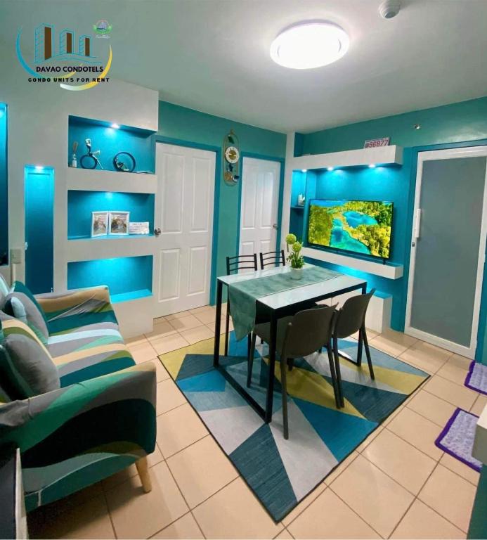 a dining room with blue walls and a table and chairs at JHS Condo in Davao City