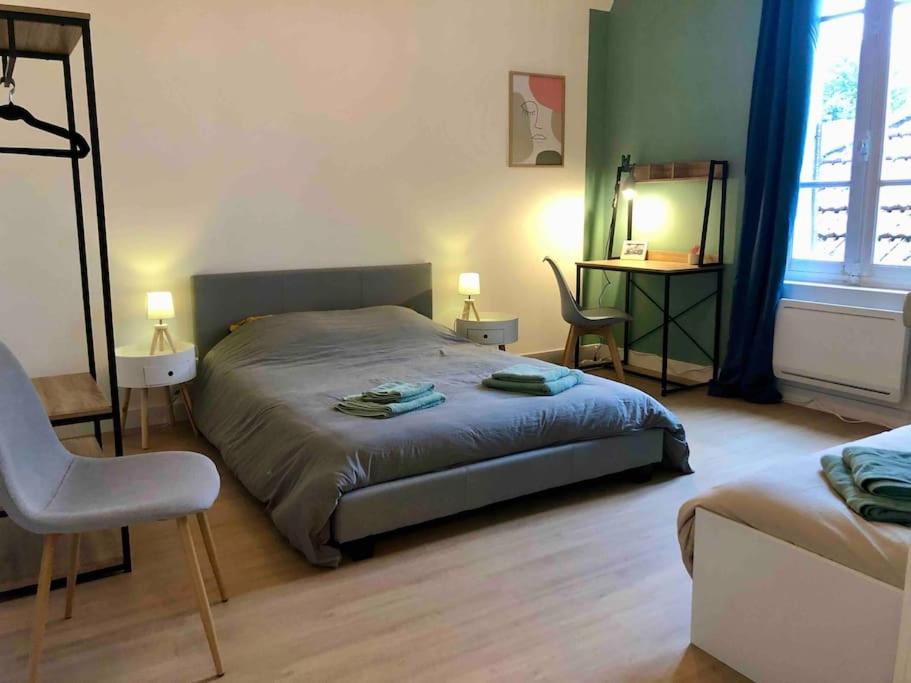 une chambre avec un lit, une table et une chaise dans l'établissement Grande Maison de ville idéale pour se réunir, à Saint-Florentin