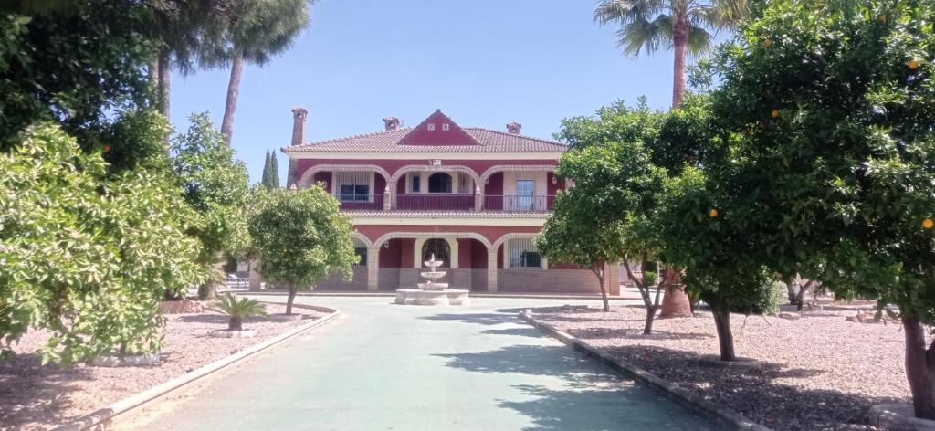 una casa rosa con una statua davanti di Hacienda el chorlo a Encinarejo De Córdoba