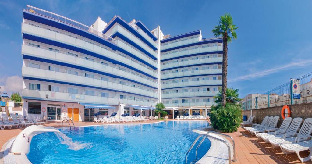 um hotel com piscina em frente a um edifício em Hotel Mar Blau em Calella