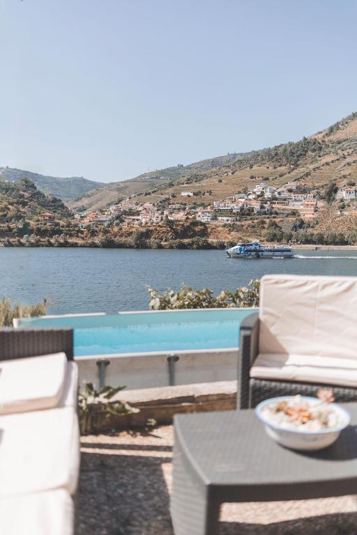 a patio with a table and chairs and a pool at Vivenda à Beira Rio in Folgosa