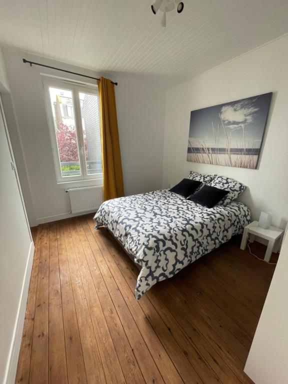 une chambre avec un lit et une fenêtre dans l'établissement Saint Vincent Océane Le Havre, au Havre