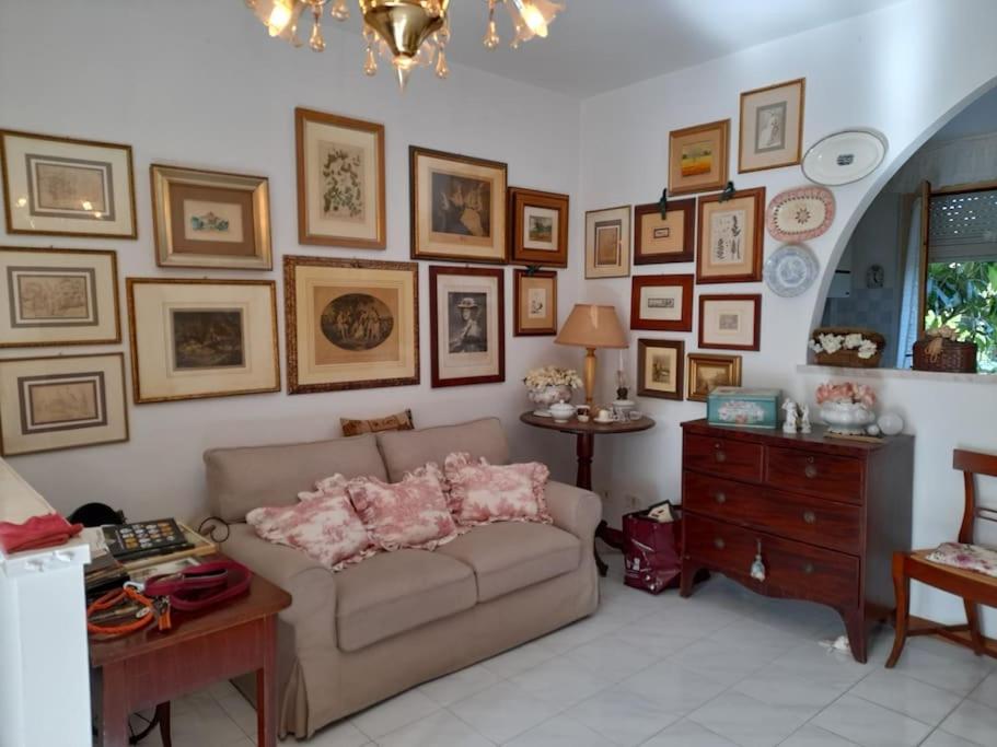 Una sala de estar con un sofá y cuadros en la pared. en La casa di Gaga - Appartamento nel Chianti senese, en Ponte A Bozzone