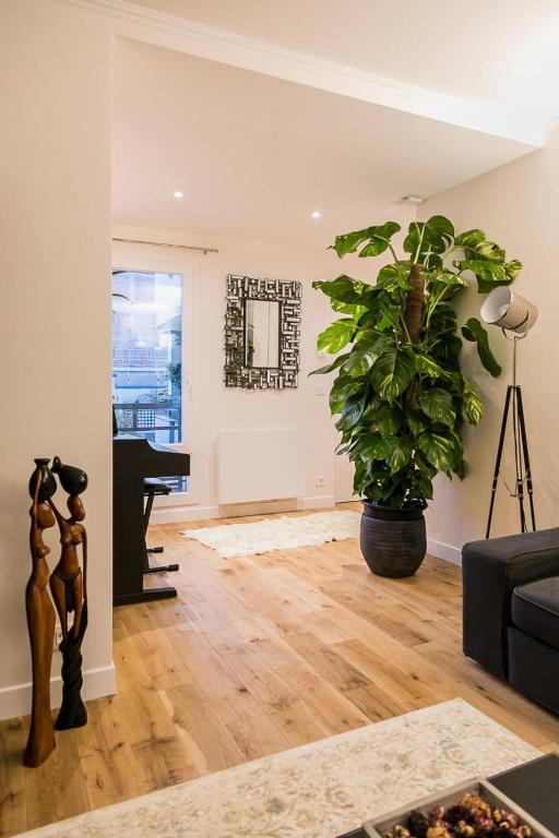 un salon avec un piano et une plante en pot dans l'établissement Cosy flat Paris 14, à Paris