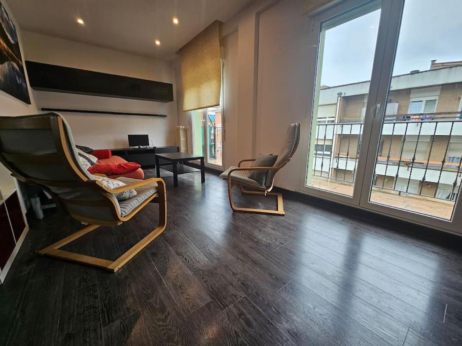 Una sala de estar con dos sillas y una mesa. en 10A05 Apartamento con vistas al parque, en Pravia