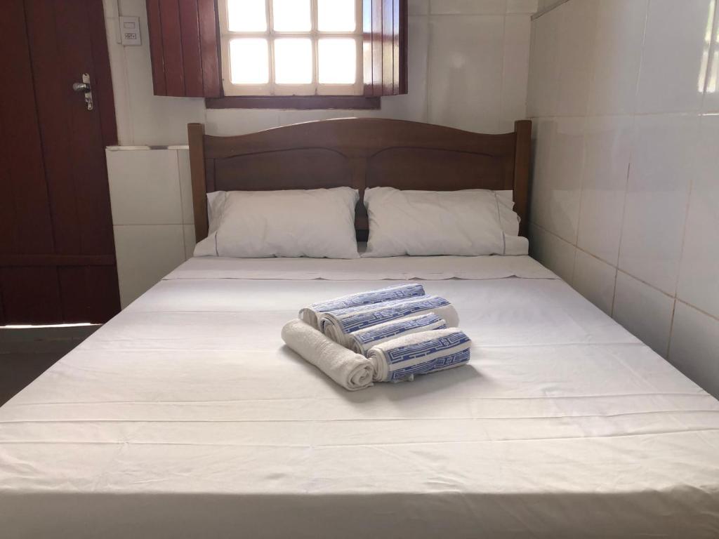 a bed with two towels sitting on top of it at Suite Diamantina in Diamantina