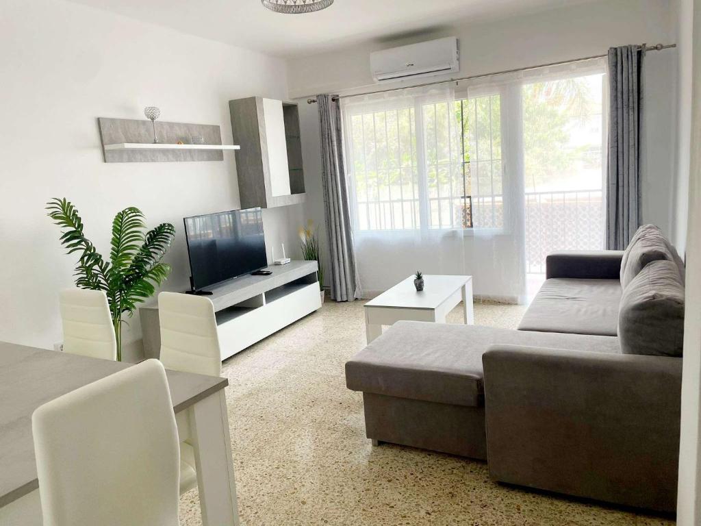 a living room with a couch and a television at Apartamento Las Niñas in Nerja
