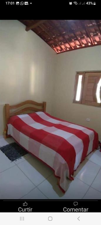 a bed in a bedroom with a red and white blanket at Casa na Serra in Bezerros