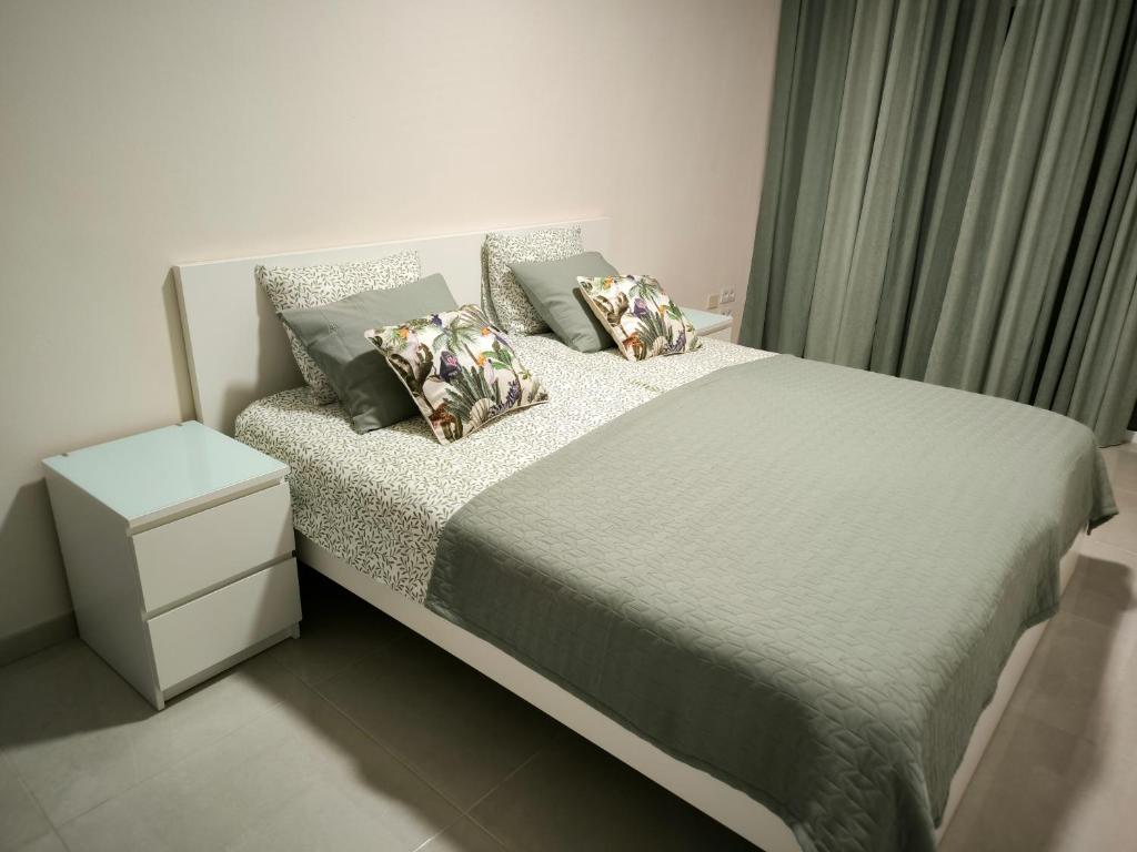 una camera da letto con un letto con cuscini di Apartamento corazon de Canteras a Las Palmas de Gran Canaria