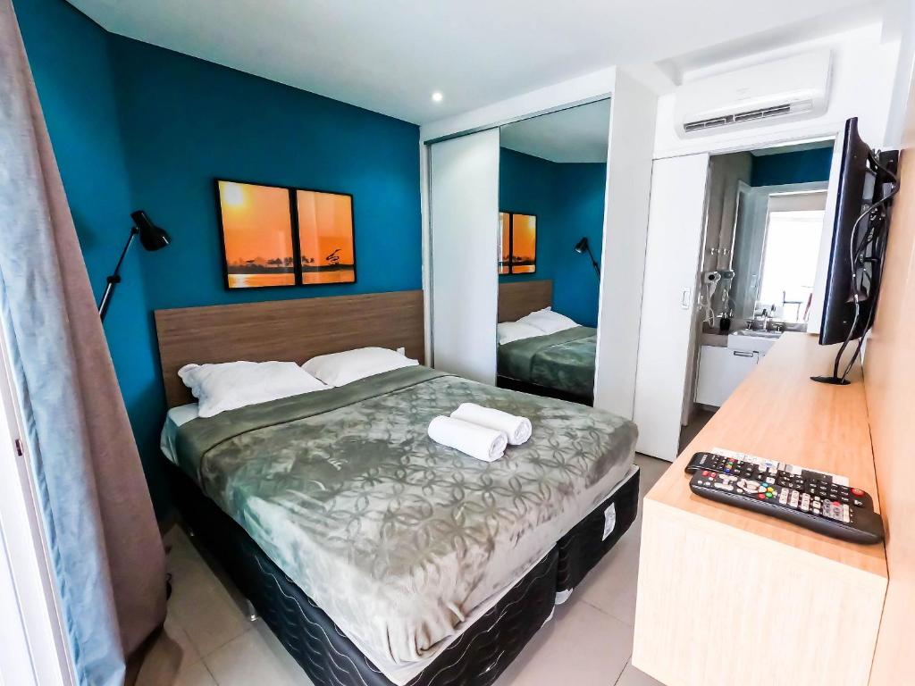 a bedroom with a large bed and a mirror at Estanconfor Vista Mar comGaragem Arrumação Diária, Ar Cond. e Cozinha in Santos