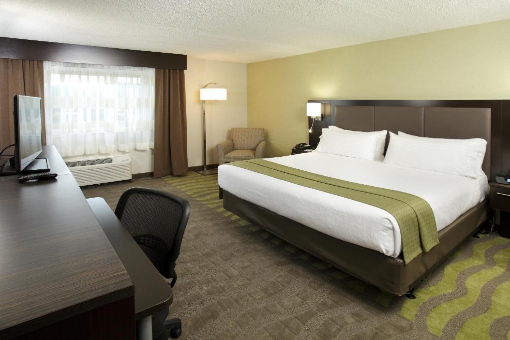 
a hotel room with a bed, chair, desk and a television at Holiday Inn Wilkes Barre - East Mountain, an IHG Hotel in Wilkes-Barre
