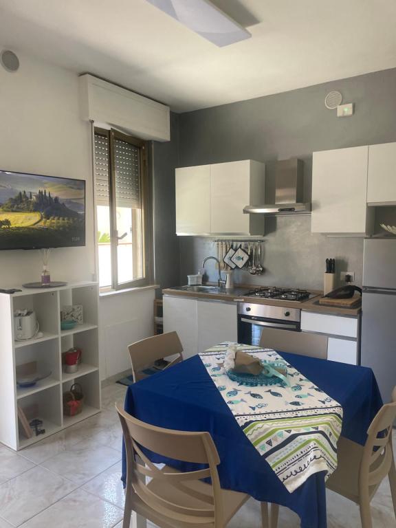 a kitchen with a table with a blue table cloth on it at Casa ORI in Montesilvano