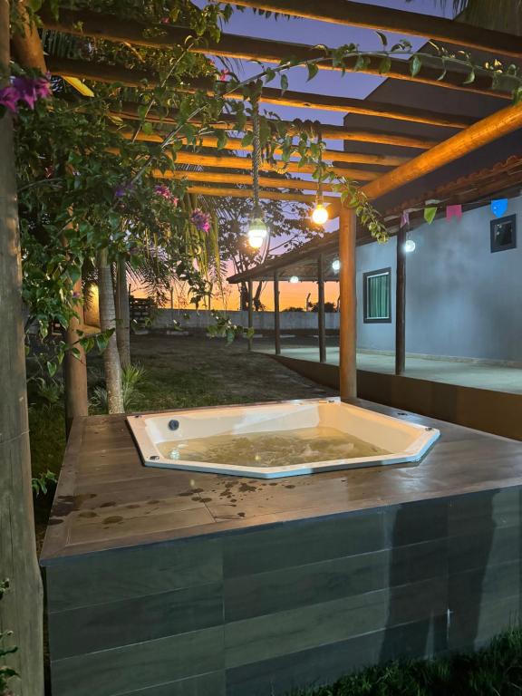 a hot tub sitting on a table under a pergola at Chácara recanto do guerreiro in Feira de Santana